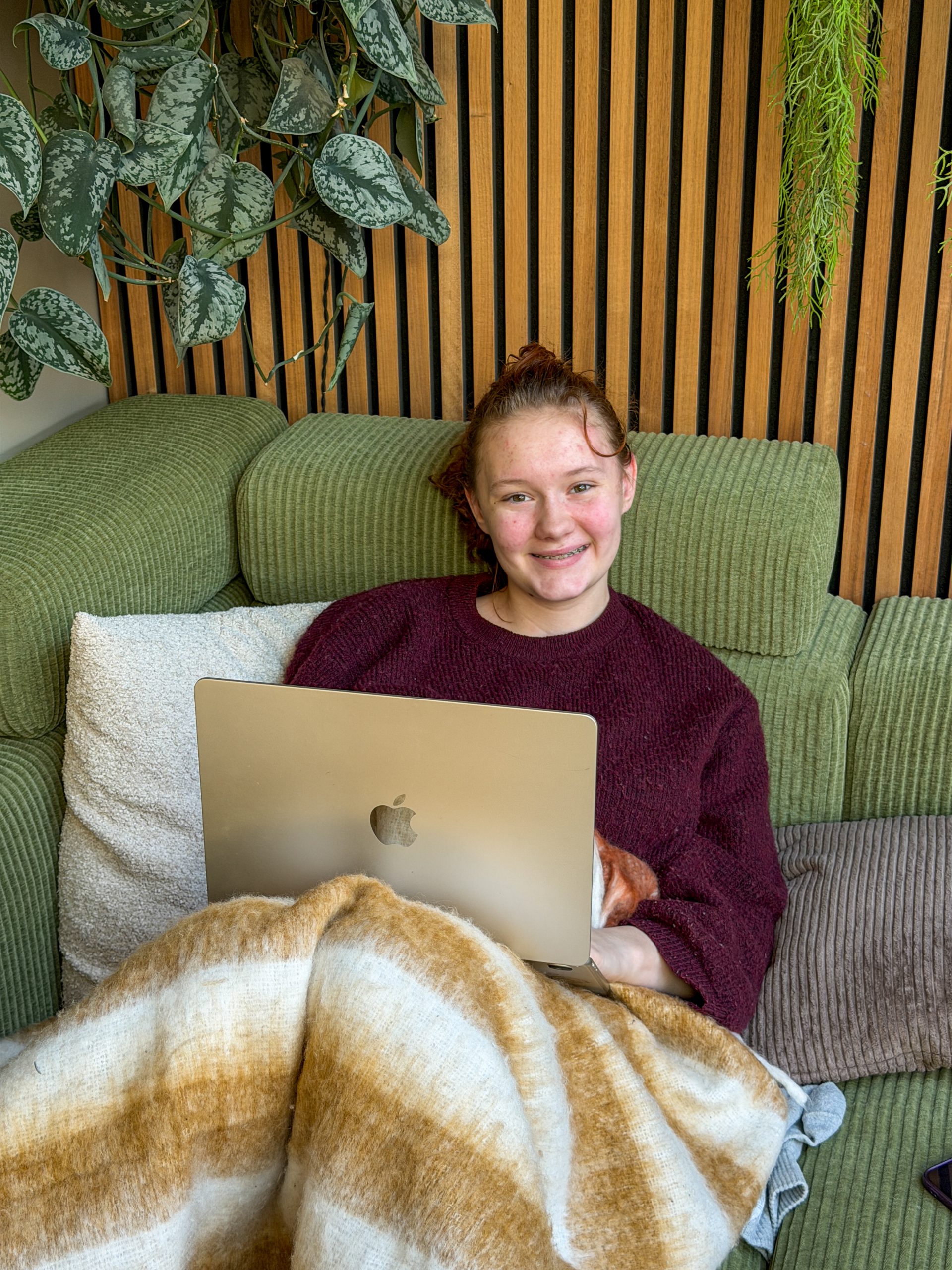 Amaranthe aan het werk op de laptop op de bank
