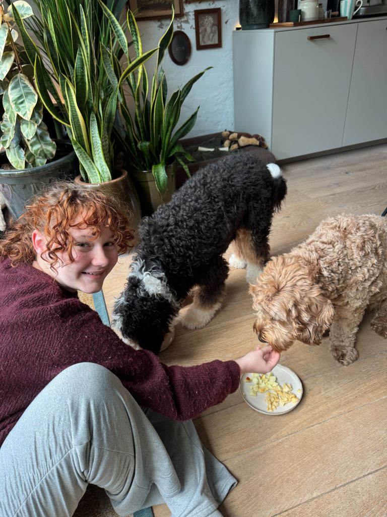 Amaranthe geeft een hond appelstukjes uit haar hand