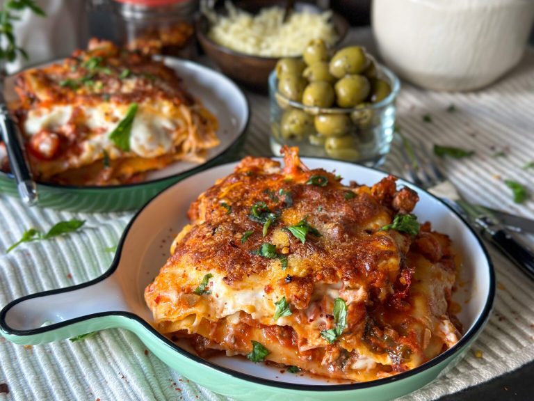 lasagne met gehakt en bechamelsaus uit de oven geserveerd op bord