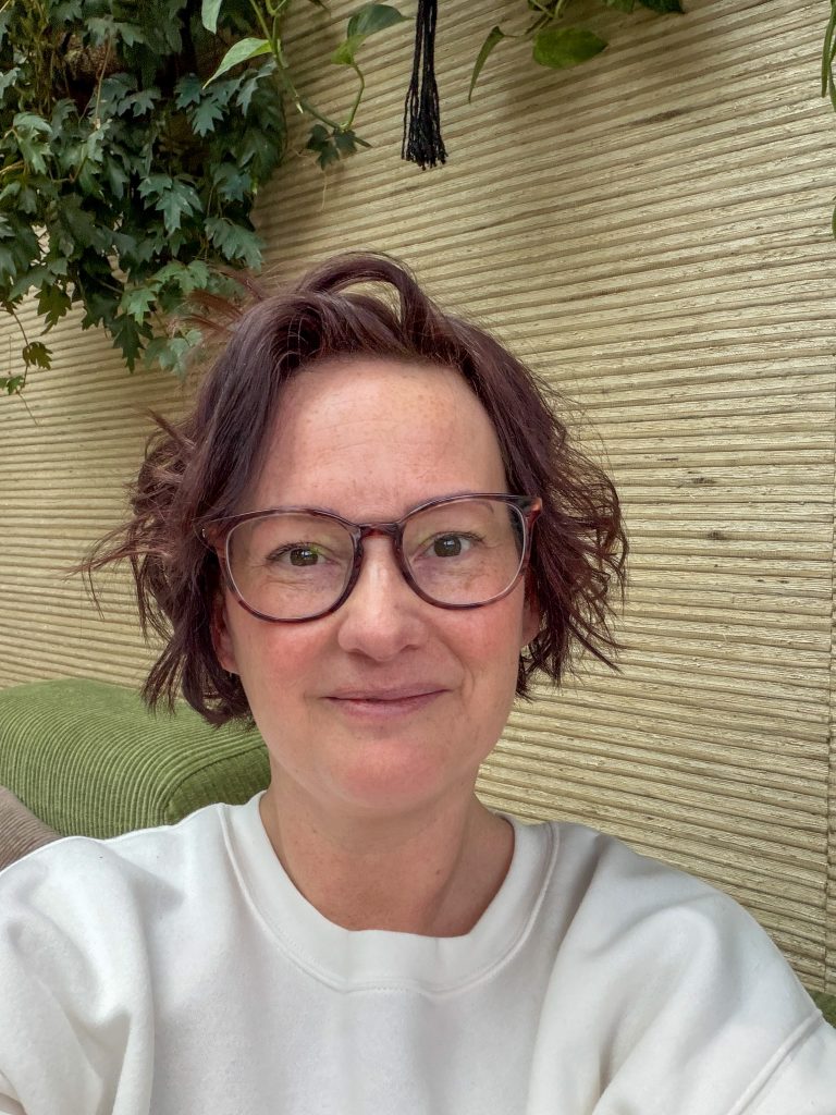 Marie Louise maakt een selfie op de groene bank in de woonkamer.