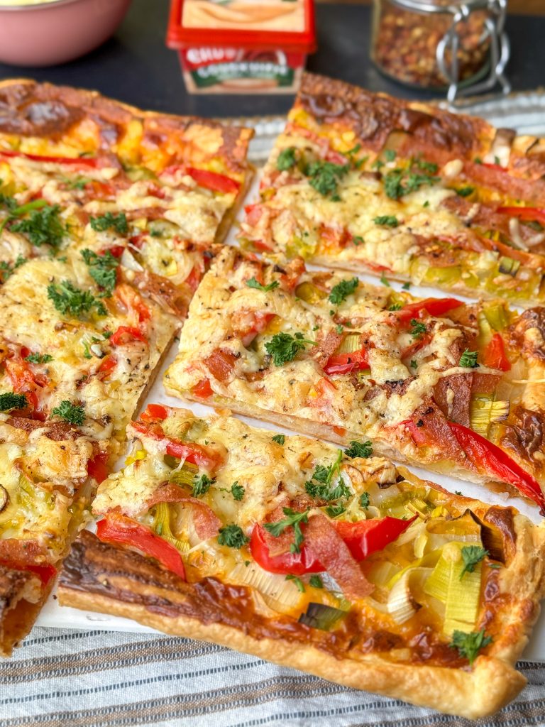 In stukken gesneden plaattaart met pikantje, groenten, salami en kaas