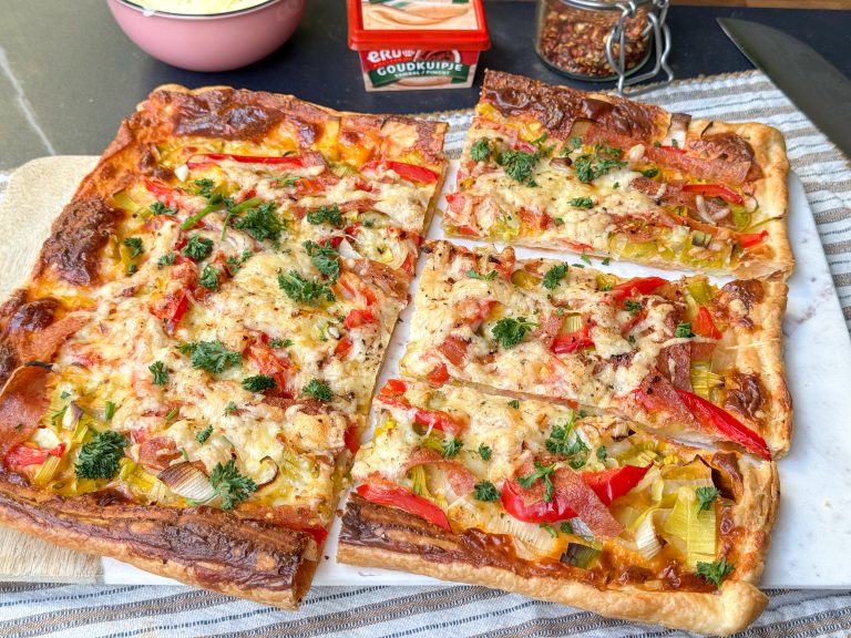 Plaattaart met pittige smeerkaas, paprika, prei en salami in stukken gesneden